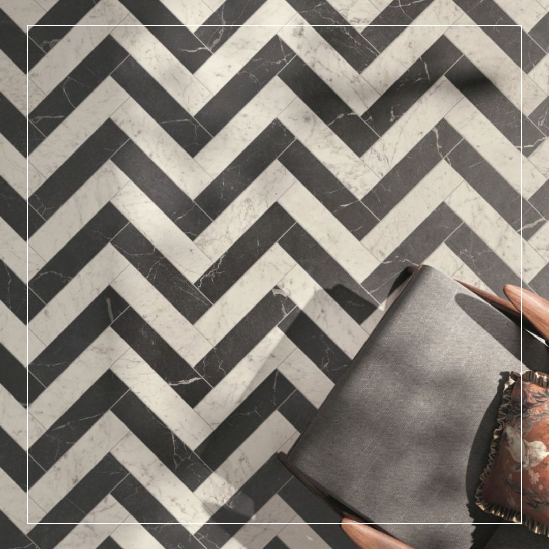 Black and white marble-effect tiles laid in a bold herringbone pattern