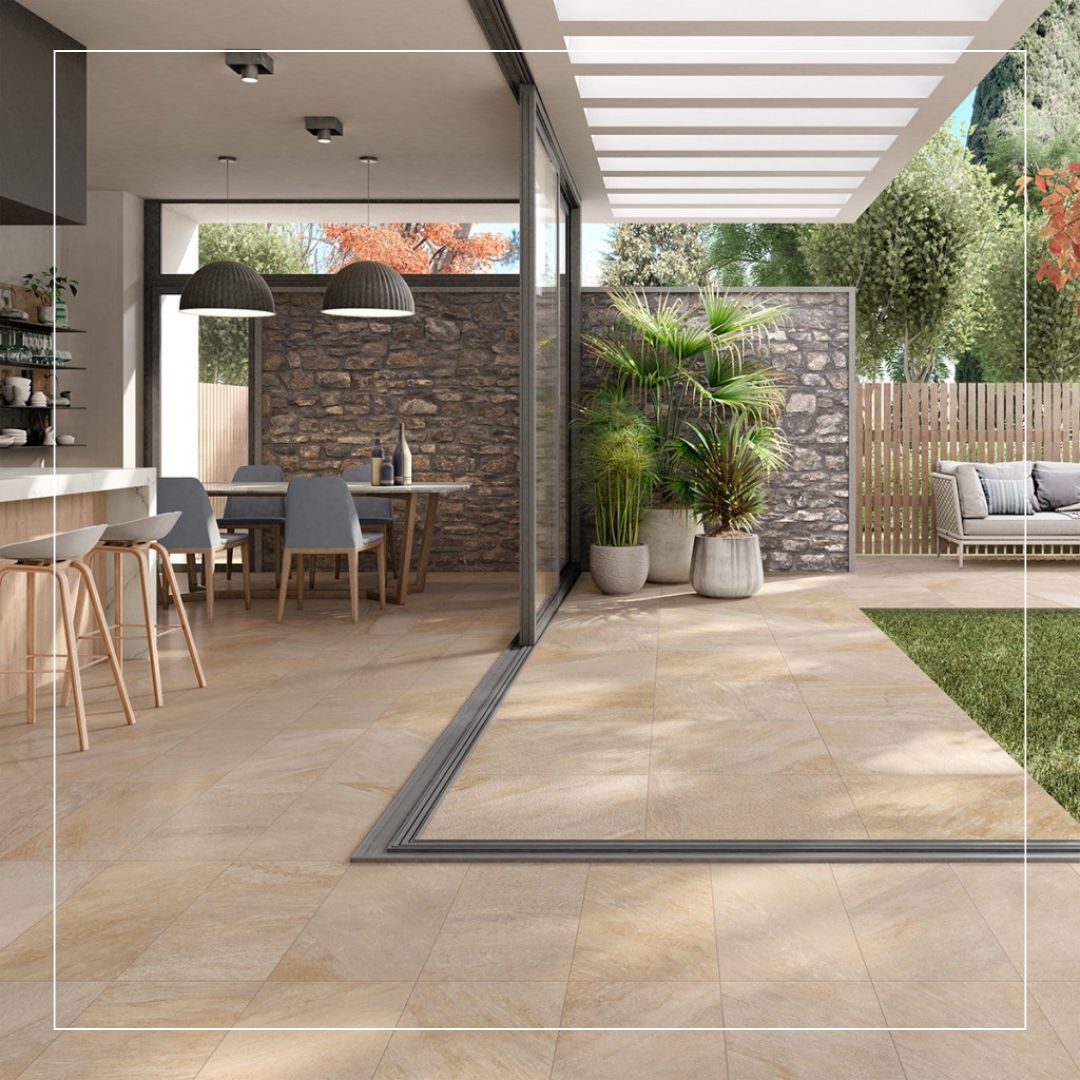Large format beige stone effect porcelain tiles used for a seamless indoor to outdoor terrace design.