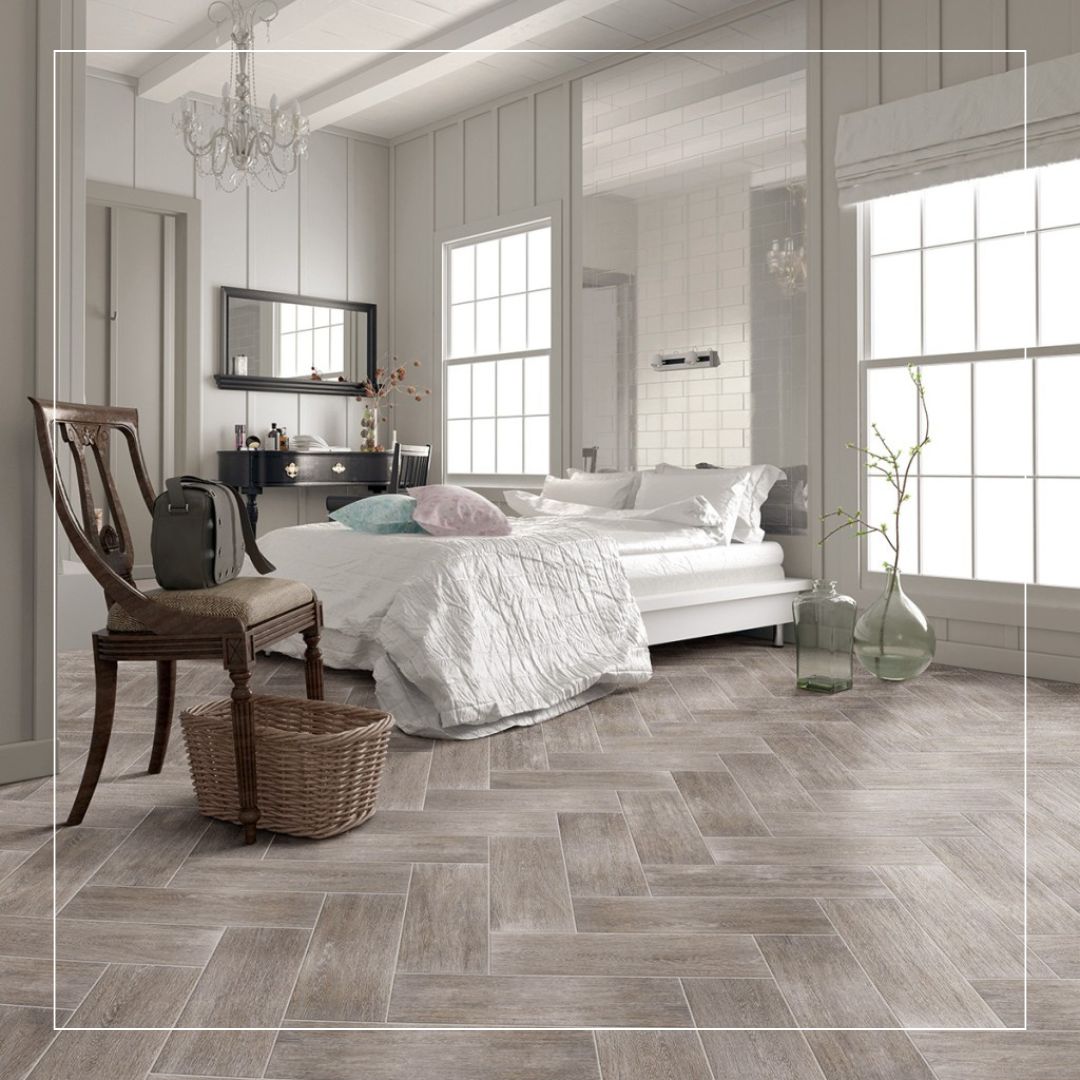 Elegant bedroom featuring grey wood-effect porcelain floor tiles laid in a herringbone pattern