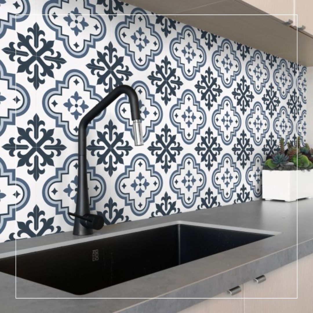Kitchen backsplash featuring patterned ceramic tiles in a blue, grey, and white colour scheme, creating a balanced 60–30–10 palette that pairs with a grey worktop and matte black tap