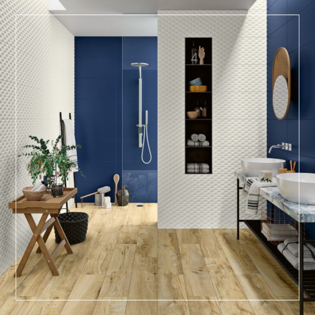 Modern bathroom interior with blue and white textured wall tiles, walk-in shower, wooden-look floor tiles