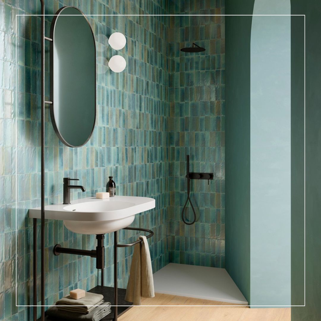 Bathroom interior featuring glossy green and aqua-toned wall tiles laid in a vertical pattern
