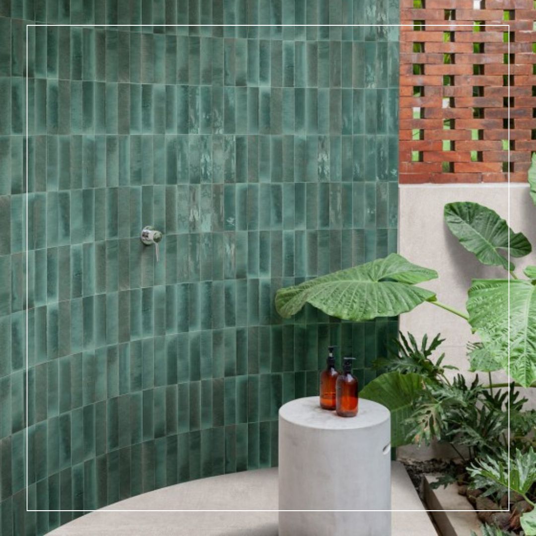 Curved wall clad in vertical green glazed tiles with subtle tonal variation