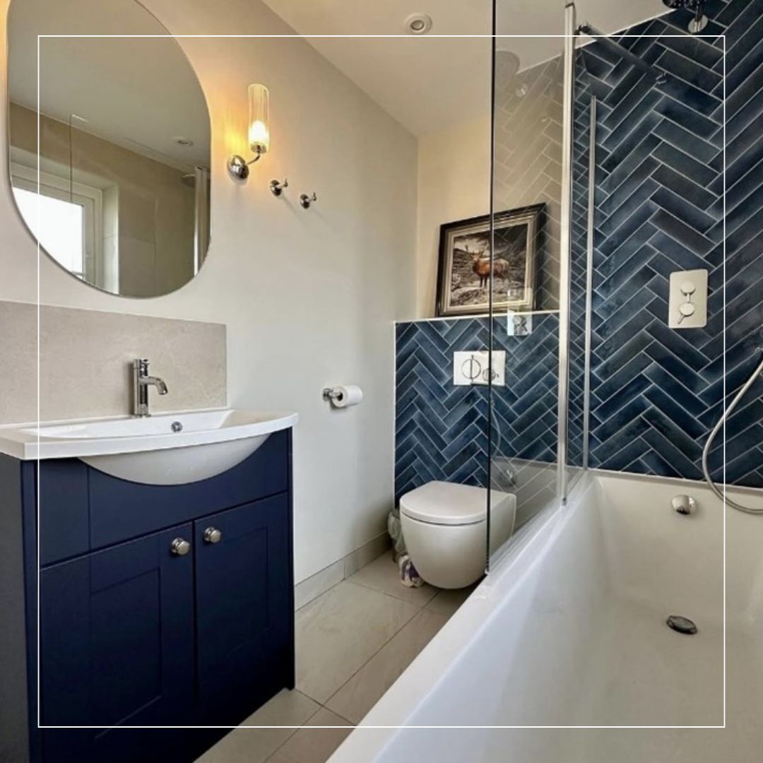 Bathroom design showcasing blue herringbone wall tiles paired with soft neutral wall tiles and warm beige flooring