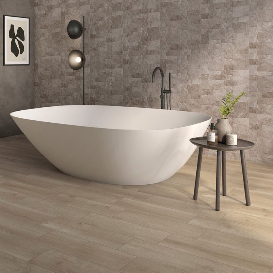 Warm neutral bathroom with freestanding bath, wood-effect floor tiles, textured stone feature wall and black freestanding bath filler
