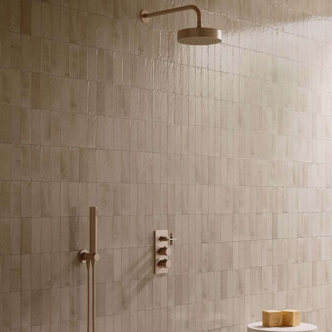 Warm neutral walk-in shower with small format beige wall tiles, brushed brass rainfall shower and minimalist spa-inspired design