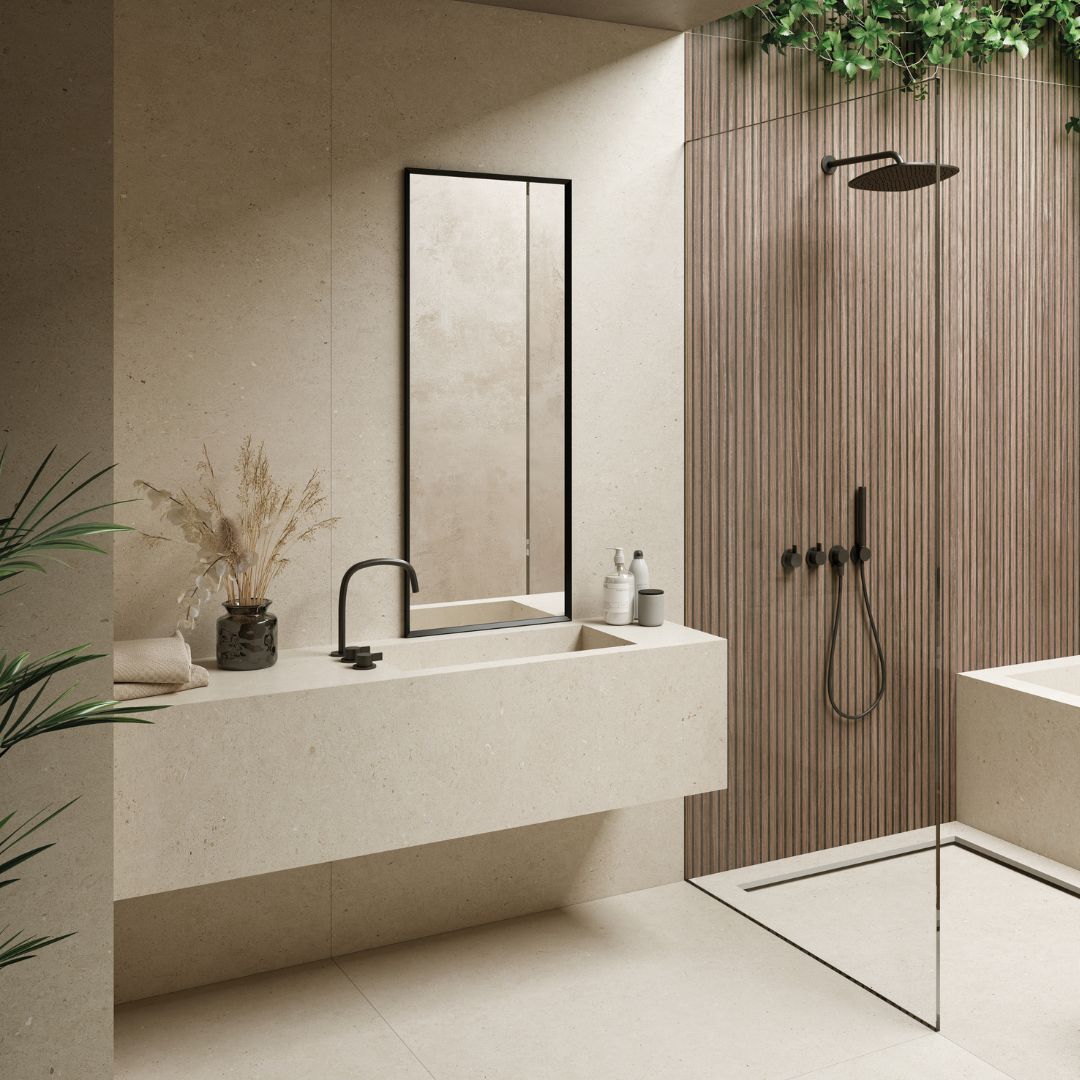 Warm neutral bathroom with beige stone-effect tiles, fluted feature wall, walk-in shower, floating vanity unit and black brassware