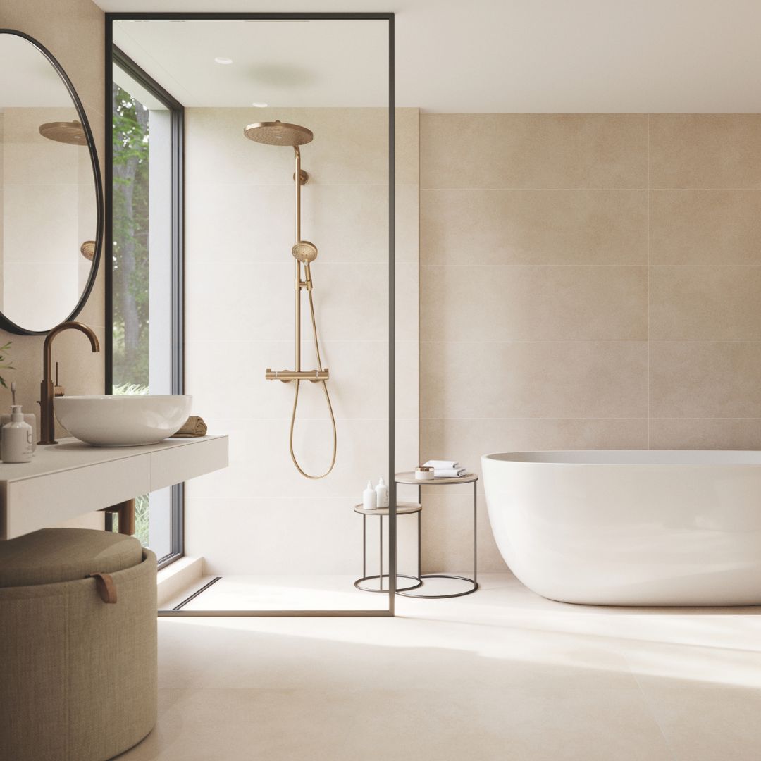 Warm neutral bathroom with beige stone-effect tiles, freestanding bath, walk-in shower, brushed brass fittings and floating vanity unit