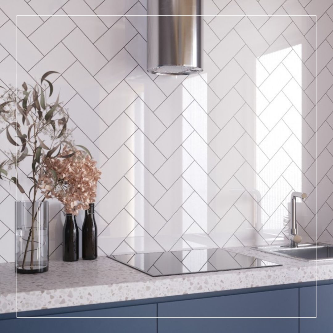 Modern kitchen with white herringbone splashback tiles, terrazzo countertop, and blue cabinets