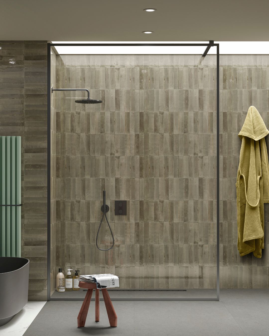 Contemporary wet room with large grey floor tiles, walk-in shower with linear drain, textured grey wall tiles and black shower fittings