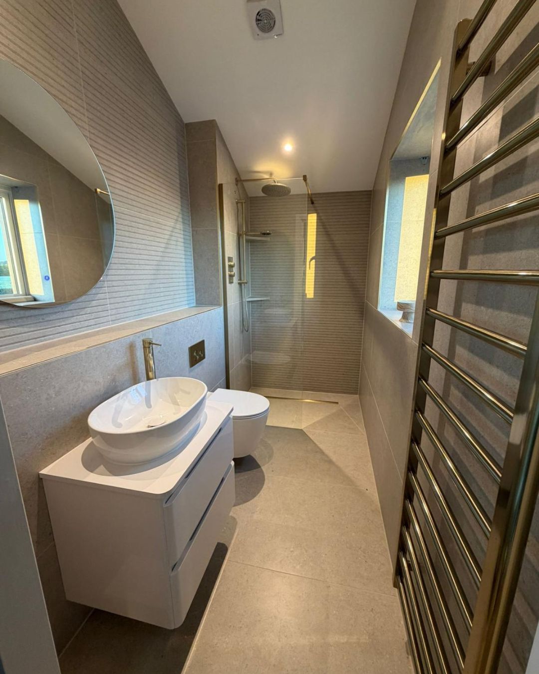 Small modern wet room with large grey stone-effect floor tiles, walk-in shower